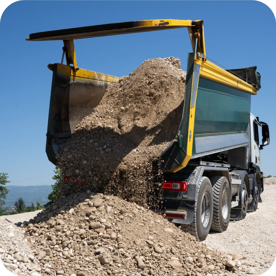 Tipper truck unloading gravel on site